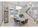 Bright dining area with modern lighting, neutral decor, and a view of the home's staircase at 1763 Standing Rock Cir, Oakland, FL 34787