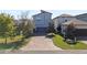 Spacious driveway leading to a modern home with well-maintained lawn and mature trees at 1763 Standing Rock Cir, Oakland, FL 34787