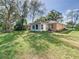 Well-maintained backyard showcasing the home's exterior, featuring a spacious lawn and mature trees at 2031 Roseway Ave, Deltona, FL 32738