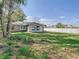 Lush backyard with a large lawn, mature trees, and partial fencing, providing a private outdoor space at 2031 Roseway Ave, Deltona, FL 32738