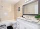 Elegant bathroom featuring a tub, toilet, and a vanity with a large mirror and stylish decor at 2031 Roseway Ave, Deltona, FL 32738