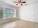 Light filled bedroom has a large window overlooking a view of the outdoors and a ceiling fan at 2031 Roseway Ave, Deltona, FL 32738