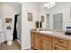 Well-lit bathroom featuring a sink with a mirror and a shower with dark curtains at 2213 Jetta Way, The Villages, FL 32162