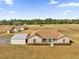 An aerial view of a one-story home with brick accents and a huge front and side yard at 36525 Reserve Dr, Eustis, FL 32736