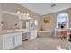 A luxurious bathroom with a makeup vanity, double sinks, soaking tub, and arched window at 36525 Reserve Dr, Eustis, FL 32736