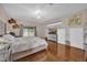 Bright bedroom featuring hardwood floors, an upholstered bed frame, and a sliding glass door to the backyard at 36525 Reserve Dr, Eustis, FL 32736