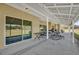 Covered patio with seating area, sliding glass doors, and outdoor dining space overlooking the expansive backyard at 36525 Reserve Dr, Eustis, FL 32736