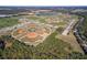 An aerial view of a sports complex featuring baseball fields, soccer fields, and a lake with a fountain at 3978 Old Dunn Rd, Apopka, FL 32712