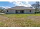 Backyard view showcasing the home's exterior, screened-in lanai, and lush lawn at 3978 Old Dunn Rd, Apopka, FL 32712