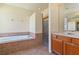 Bathroom featuring a soaking tub, glass enclosed shower, and single sink vanity at 3978 Old Dunn Rd, Apopka, FL 32712