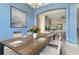 Dining room with wood table and chairs, decorated with flowers and place settings at 3978 Old Dunn Rd, Apopka, FL 32712