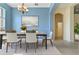 Serene dining room featuring blue walls, a modern chandelier, and a wooden dining table at 3978 Old Dunn Rd, Apopka, FL 32712