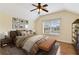 Comfortable main bedroom with a ceiling fan, large window, and a stylish leather bench at 3978 Old Dunn Rd, Apopka, FL 32712