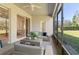 Cozy screened-in patio with comfortable seating, ceiling fan, and view of the backyard, perfect for outdoor relaxation at 3978 Old Dunn Rd, Apopka, FL 32712