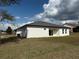 Back of the house featuring a modern exterior, manicured lawn, and a gray roof at 4650 Sw 139Th Pl, Ocala, FL 34473