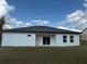 Exterior shot of the back of the home showing a sliding glass door and minimal landscaping at 4650 Sw 139Th Pl, Ocala, FL 34473