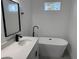 Bright bathroom featuring soaking tub, dual vanity, and modern fixtures at 4650 Sw 139Th Pl, Ocala, FL 34473
