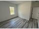 Bright bedroom features gray wood flooring, a window, and a door at 4650 Sw 139Th Pl, Ocala, FL 34473