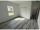 Bedroom featuring a large window, double closet, and gray wood floors at 4650 Sw 139Th Pl, Ocala, FL 34473