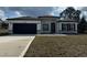 Beautiful single-story home with a two-car garage, modern design, and well-manicured lawn at 4650 Sw 139Th Pl, Ocala, FL 34473