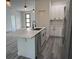 Well-lit kitchen boasts an island with quartz countertop, modern faucet, and stainless steel appliances at 4650 Sw 139Th Pl, Ocala, FL 34473