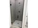 Modern walk-in shower with gray tiled walls and a clear glass door at 4650 Sw 139Th Pl, Ocala, FL 34473