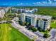 Aerial view of building featuring well-maintained landscaping, ample parking, and lush greenery, creating a welcoming atmosphere at 5300 S Atlantic Ave # 6-206, New Smyrna Beach, FL 32169