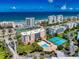 Gorgeous aerial view showcasing the community amenities, including the pool and tennis courts, along with the ocean view at 5300 S Atlantic Ave # 6-206, New Smyrna Beach, FL 32169