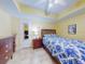This bright bedroom features a ceiling fan, a tiled floor, and a mirrored closet at 5300 S Atlantic Ave # 6-206, New Smyrna Beach, FL 32169