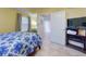 This bright bedroom has a ceiling fan, a tiled floor, and a TV on a shelf at 5300 S Atlantic Ave # 6-206, New Smyrna Beach, FL 32169