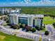 Aerial view of building featuring well-maintained landscaping, ample parking, and lush greenery, creating a welcoming atmosphere at 5300 S Atlantic Ave # 6-206, New Smyrna Beach, FL 32169