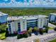 Aerial view of building featuring well-maintained landscaping, ample parking, and lush greenery, creating a welcoming atmosphere at 5300 S Atlantic Ave # 6-206, New Smyrna Beach, FL 32169