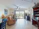 Comfortable living area with plush seating, tile floors, and access to a balcony at 5300 S Atlantic Ave # 6-206, New Smyrna Beach, FL 32169