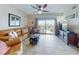 Bright living room with tile floors, comfortable seating, and access to a private balcony at 5300 S Atlantic Ave # 6-206, New Smyrna Beach, FL 32169