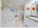 Well-lit primary bathroom with a tub, shower, and double sinks at 5300 S Atlantic Ave # 6-206, New Smyrna Beach, FL 32169
