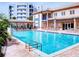 A large community pool surrounded by lounge chairs, tables, and lush landscaping at 5300 S Atlantic Ave # 6-206, New Smyrna Beach, FL 32169
