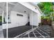 A rear exterior view features a covered patio with sleek white walls and steps leading to a modern backyard area at 5508 Meridian Way, Orlando, FL 32808