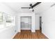 Bedroom with wood-look floors, white walls, and closet with built-in shelving units at 5508 Meridian Way, Orlando, FL 32808