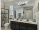 Bright bathroom features a double vanity, a walk-in shower with black trim, and white tiled floors at 619 Meadow Sage Dr, Deland, FL 32724