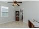 Bedroom with neutral tiled floors, a ceiling fan, two dressers, and a view of the walk-in closet at 619 Meadow Sage Dr, Deland, FL 32724
