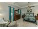 Bedroom with neutral tiled floors, a ceiling fan, tray ceiling, an upholstered chair, and dark wood furniture at 619 Meadow Sage Dr, Deland, FL 32724