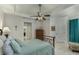 Bedroom with neutral tiled floors, a ceiling fan, a tray ceiling, blue curtains, and dark wood furniture at 619 Meadow Sage Dr, Deland, FL 32724
