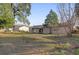 Expansive backyard with lush grass, mature trees, and patio space is great for entertaining at 6209 Beaumont Ave, Orlando, FL 32808