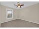 This bedroom features light beige walls, a ceiling fan, and gray wood-look flooring at 6209 Beaumont Ave, Orlando, FL 32808