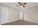 This bedroom features light beige walls, a ceiling fan, gray wood-look flooring, and doors at 6209 Beaumont Ave, Orlando, FL 32808