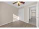 This bedroom features light beige walls, closet, gray wood-look flooring, and an open door at 6209 Beaumont Ave, Orlando, FL 32808