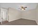 This bedroom features light beige walls, a ceiling fan, gray wood-look flooring, and open door at 6209 Beaumont Ave, Orlando, FL 32808