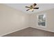 This bedroom features light beige walls, a ceiling fan, gray wood-look flooring, and a window at 6209 Beaumont Ave, Orlando, FL 32808