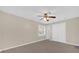 This bedroom features light beige walls, a ceiling fan, closet, gray wood-look flooring, and window at 6209 Beaumont Ave, Orlando, FL 32808