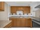 Kitchen with wood cabinets, stone countertops, neutral backsplash and stainless steel appliances at 6209 Beaumont Ave, Orlando, FL 32808